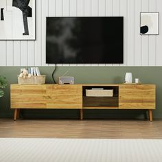 a flat screen tv mounted to the side of a wooden cabinet in a living room