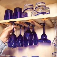 a shelf filled with lots of purple wine glasses