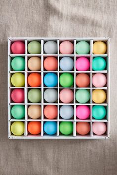 an assortment of colored eggs in a box