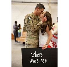 a man and woman kissing in front of a sign that says, where were we?