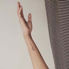 a woman's arm with a small tattoo on the left side of her arm