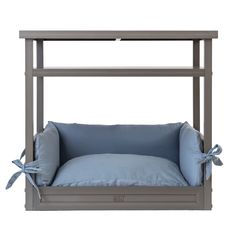 a gray dog bed with blue pillows on it