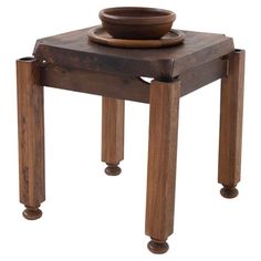 a small wooden table with a bowl on top and two legs that are attached to it