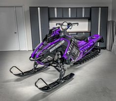 a purple and black snowmobile parked in a garage