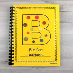 a yellow notebook with buttons on it and the letter b is for buttons written in black