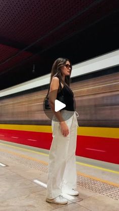 a woman standing in front of a train