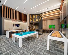 a billiards room with pool tables and televisions in the back drop area