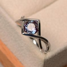 a ring with a purple diamond in it