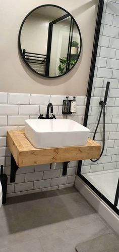 a white sink sitting under a mirror in a bathroom