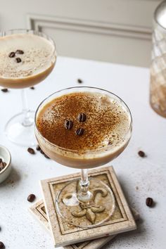 two glasses filled with drinks sitting on top of a table