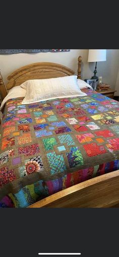 a bed with a colorful quilt on top of it