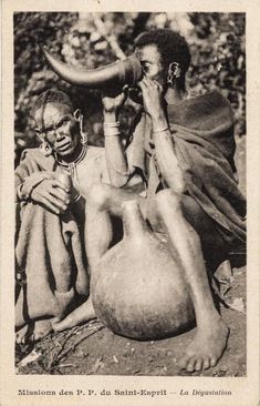 an old black and white photo of two women sitting next to each other with their faces covered in mud