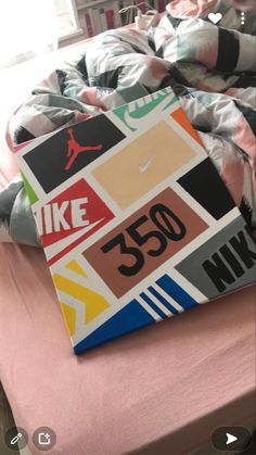 a bed topped with lots of pillows covered in colorful stickers and logos on it