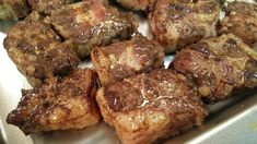 several pieces of meat sitting on top of a pan