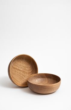 two wooden bowls sitting next to each other