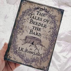 a person holding up a book with the title'the tales of beddle the bard '