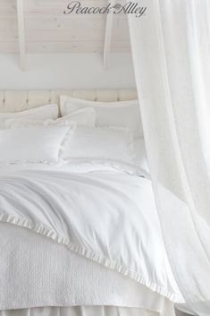 a bed with white linens and pillows in a room that looks like it has been made