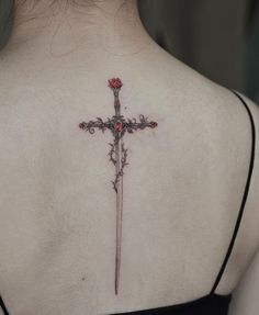 a woman with a cross tattoo on her back