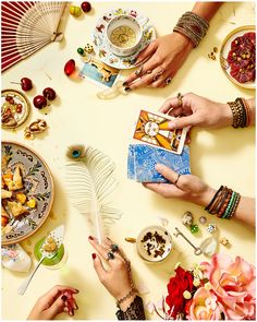 people sitting at a table with plates and dishes on it, each holding a card