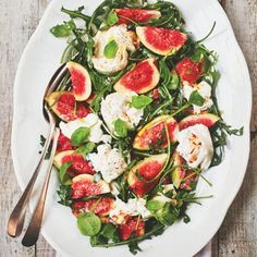 a white plate topped with greens and sliced figs