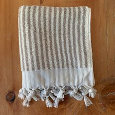 a white and grey striped blanket sitting on top of a wooden floor