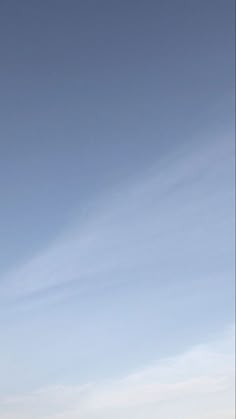 two people standing on the beach flying a kite in the sky over the water and sand