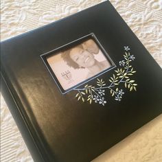 a black photo frame with an image of a baby's head and leaves on it