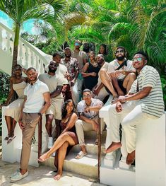 a group of people posing for a photo on steps in front of some palm trees