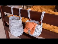 two crocheted purses hanging on a rail with a stuffed animal in them