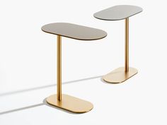 two gold and white tables sitting next to each other on top of a white floor