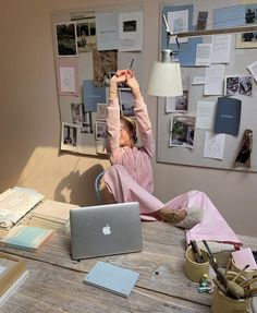 a woman sitting at a table with her laptop and cell phone in front of her