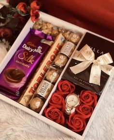 a box filled with assorted chocolates and roses