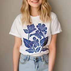 Embrace the fall season with this linocut blue floral shirt, a perfect white floral boho shirt for women. This vintage boho flower shirt makes an ideal autumn gift, combining the charm of fall floral designs with timeless style. 𝗣𝗥𝗢𝗗𝗨𝗖𝗧 𝗗𝗘𝗧𝗔𝗜𝗟𝗦 🔷 Comes in 2 colors  Ivory(light yellow) and White 🔷 100% cotton 🔷 Pre-shrunk 🔷 Relaxed fit 𝗣𝗢𝗟𝗜𝗖𝗜𝗘𝗦 Products may be returned only if damaged  or wrong product received with in 30 days  of delivery. 𝗣𝗥𝗢𝗖𝗘𝗦𝗦𝗜𝗡𝗚 𝗔𝗡𝗗 𝗦 Spring Shirt With Unique Print And Relaxed Fit, Blue Floral Print Shirt For Fall, Trendy Blue Floral Print Shirt, Trendy Cotton Blouse With Floral Embroidery, White Tops With Unique Print, Spring Blue Floral Print Shirt, Blue Tops With Plants Print And Relaxed Fit, Trendy Blue Floral Print T-shirt, Bohemian Cotton Tops With Unique Print