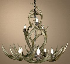 the antler chandelier is made out of wood and has candles in it