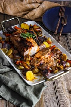 a white plate topped with chicken, potatoes and carrots on top of a wooden table