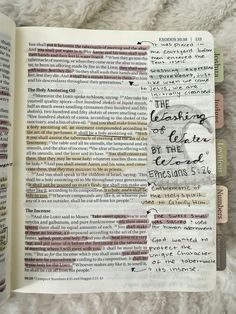 an open bible with handwritten words on the pages and some other writing in it