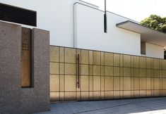 an outside view of a building with a metal door and wall in the foreground