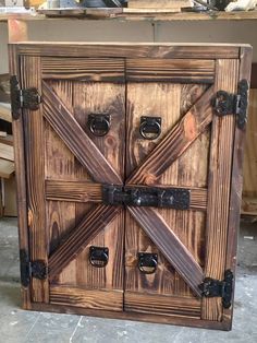 an old wooden cabinet with metal handles and latches on the doors is being worked on