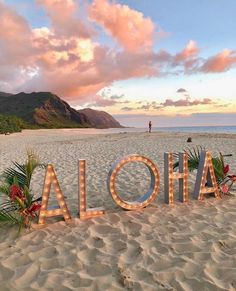 the word aloha is lit up at the beach