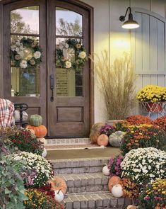 the front door is decorated with flowers and pumpkins