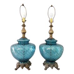 a pair of blue glass lamps sitting on top of each other