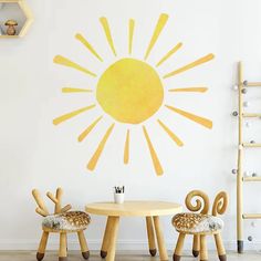 two chairs and a table in front of a wall with the sun painted on it