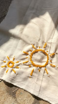 an embroidered piece of cloth with the sun drawn on it