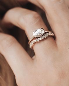 a woman's hand with a diamond ring on her left hand and an engagement ring on her right hand