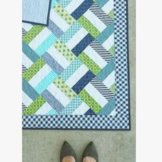 a pair of shoes sitting on top of a blue and green quilted floor mat