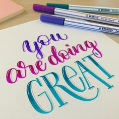 the words you are doing great written on a piece of paper next to some markers