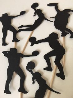 the cake toppers are made to look like silhouettes of people playing basketball