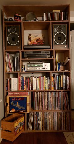 a bookshelf filled with lots of different types of music and audio equipment on top of wooden shelves