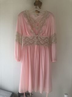 This beautiful vintage pink nightgown and robe is a unique and rare find. This set does have various stains throughout, but if treated with further care it can be a wonderful addition to your vintage collection.  Robe Bust Measurement: 30"  Robe Waist Measurement: 26"  Robe Length: 35"  Nightgown Bust Measurement: 33" Nightgown Waist Measurement: 27" Nightgown Length: 35" Vintage Wedding Sleepwear For Spring, Pink Feminine Sleepwear For Wedding, Pink Dress With Lace Trim For Wedding Night, Vintage Wedding Nightgown For Spring, Elegant Pink Vintage Dress For Daywear, Pink Feminine Nightgown For Wedding Night, Pink Long Sleeve Nightgown For Wedding Night, Feminine Pink Vintage Dress For Wedding, Feminine Pink Sleepwear For Wedding