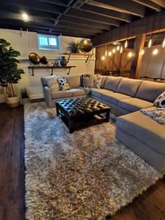 a living room filled with furniture and lots of lights hanging from the ceiling above it